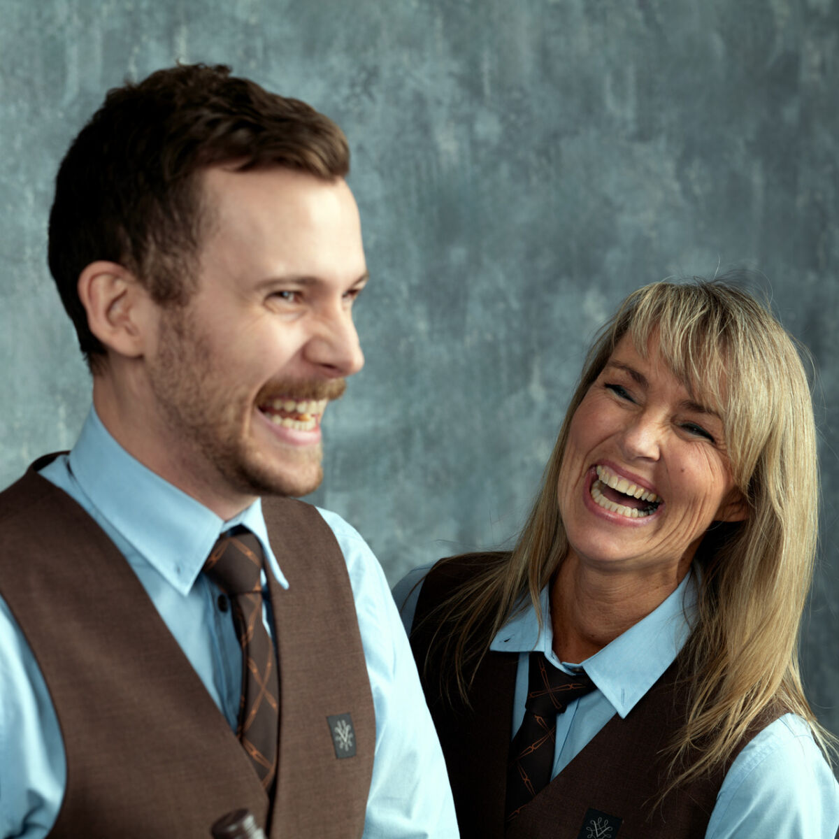 Bilde av to ansatte i Vinmonopolet som ler sammen.